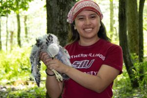photo of gal holding banded Red-shouldered hawk chick