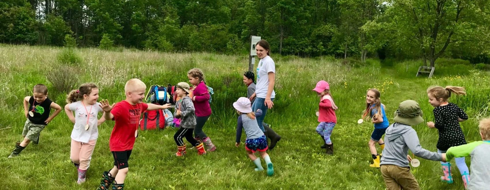Young children playing a tag game at summer camp