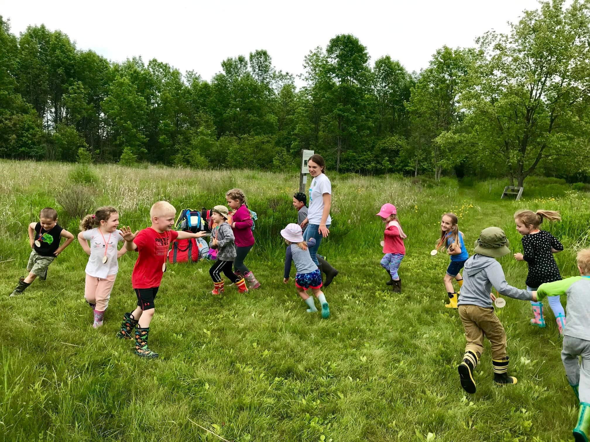 Young children playing a tag game at summer camp
